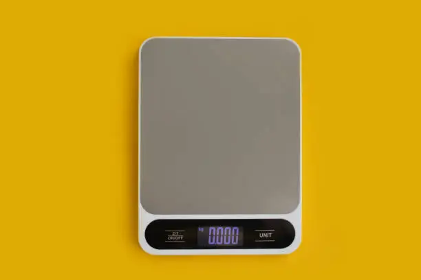 Electronic kitchen scales on a colored background