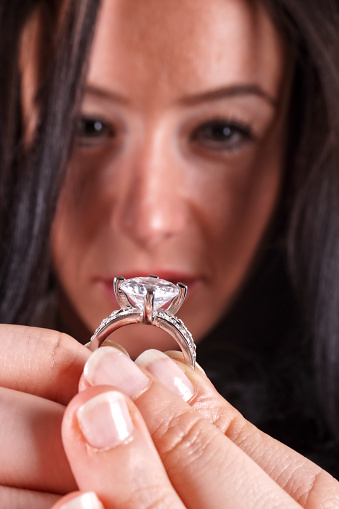 Close up portrait of young woman showing diamond engagement ring