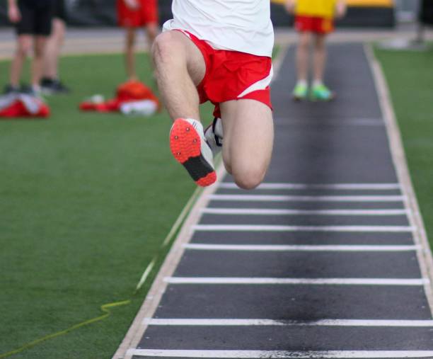 istock Young athlete in the air jumping during a long jump competition 1458009679