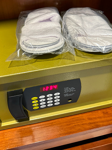 Stock photo showing close-up view of a hotel closet safety deposit box for valuables and money with electronic display of 1234 digit password over keypad.