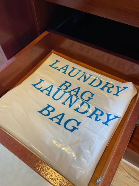 Close-up image of wooden, hotel draw containing a plastic laundry bag, elevated view