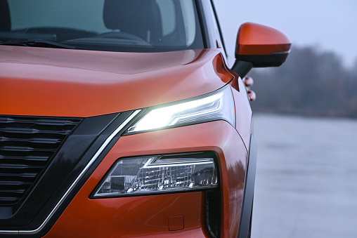 Berlin, Germany - 20 January, 2023: View on the LED headlight with Nissan X-Trail on a road. This model is one of the most popular SUV vehicles in Europe.