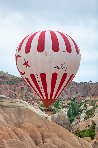 Avanos, Turkey - Jun 18, 2011: Panoramic image (stitch of three images) of Hot Air Balloons over Cappadocia. In the middle the table mountain \