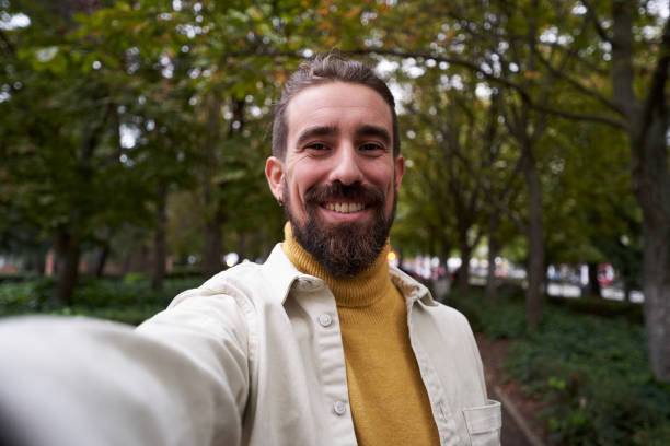 istock Cheerful caucasian man taking a selfie outdoors, looking at camera smiling. 1458019428