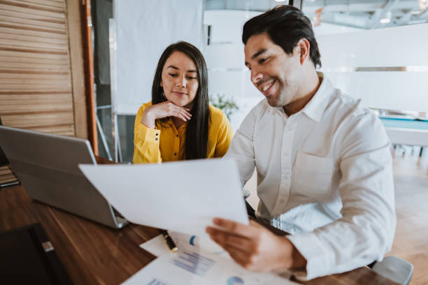 istock Financial report being analyzed by two coworkers 1458023473