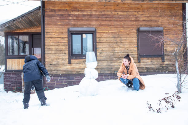 mother and son making a snowman outdoor