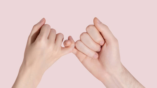 Man and woman hold each other with little fingers. Ð¡oncept of friendly relations. stock photo