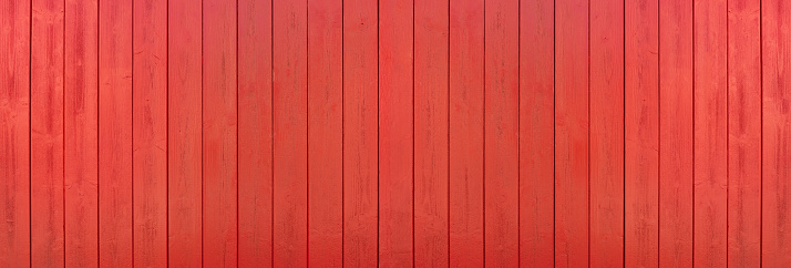 Red painted panoramic wooden wall made of vertical boards in close-up