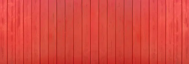 Red painted panoramic wooden wall made of vertical boards in close-up