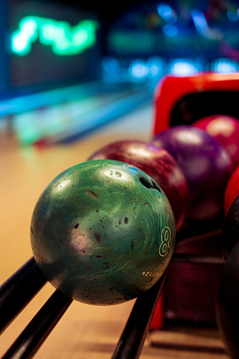 Colorful bowling balls stand in a row