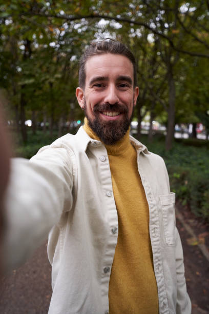 istock Cheerful caucasian man taking a selfie outdoors, looking at camera smiling. 1458025883