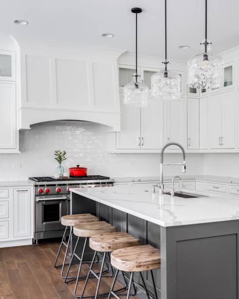 istock A kitchen kitchen with bar stools sitting at a large grey island. 1458026697
