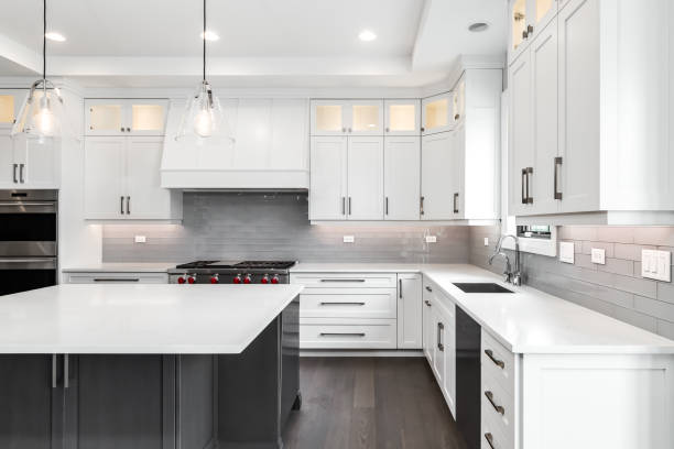istock A modern kitchen with white cabinets, a large island, and stainless steel appliances. 1458026764