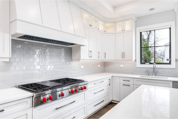 istock A modern kitchen with white cabinets, a large island, and stainless steel appliances. 1458026799
