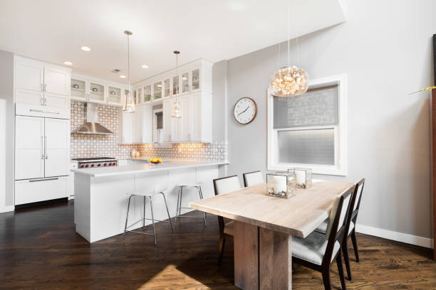 istock A dining room with a chandelier hanging above and a white kitchen. 1458026826