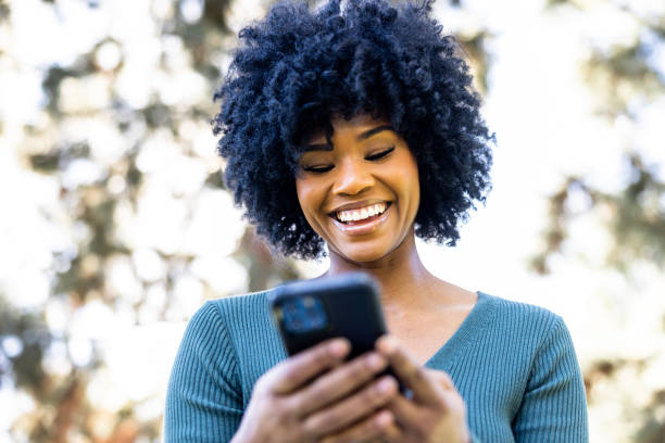 istock Beautiful young black woman texting on smartphone 1458027964