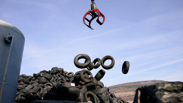 Crane hook dropping stacked tires at the landfill