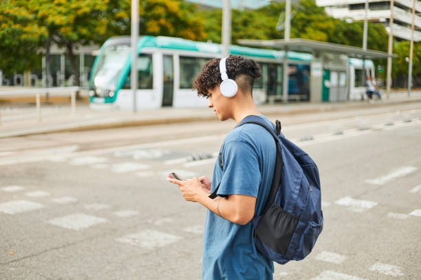 istock Young hispanic man walking down the street using his mobile phone 1458032988