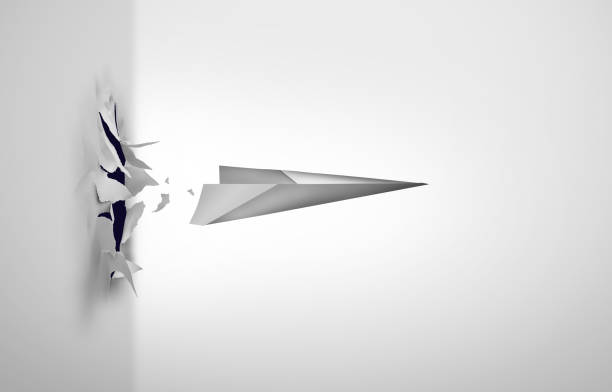 Breaking Through Breaking through and overcoming challenges or surmounting difficulties as a paper airplane blasting out of a wall as a symbol to overcome obstacles and achieving despite difficulties as a business success metaphor. emergence stock pictures, royalty-free photos & images
