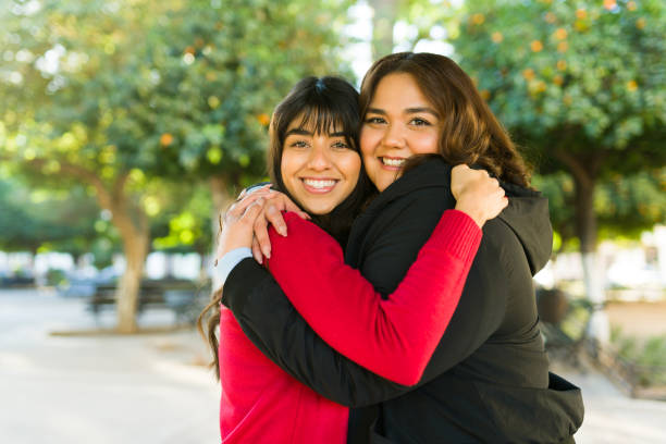 istock Best friends embracing outdoors looking cheerful 1458035780