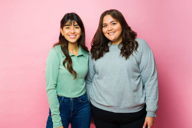 istock Happy best friends posing in a pink background 1458036044
