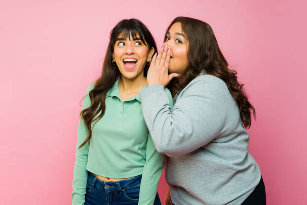 istock Women best friends sharing secrets looking surprised 1458036333