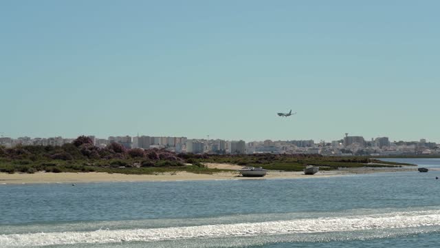 Beautiful sea view of the Ria Formosa park of Faro. landing plane at airport with a view of city