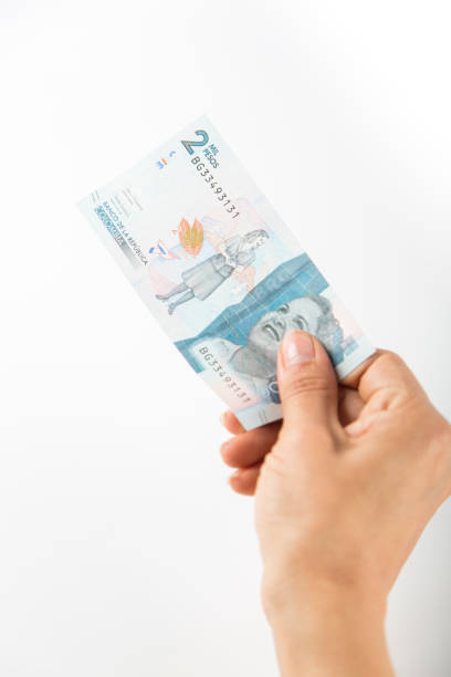 istock a person pays with a two thousand colombian peso bill. vertical image 1458048344