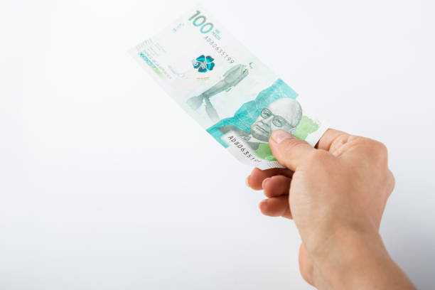 istock a person hands over a one hundred thousand colombian pesos bill 1458048456