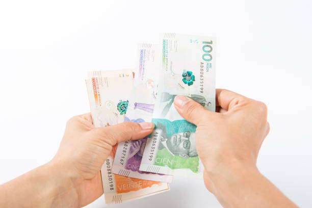 istock a woman holding Colombian banknotes in her hands. 1458048549