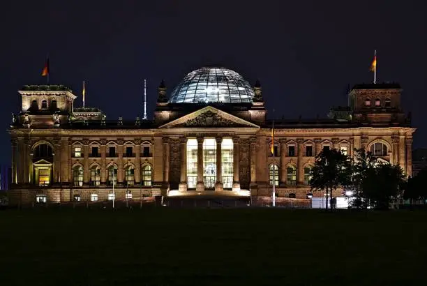 Front view of Reichstag building at night in Berlin photographed during the enclosure of the park in front.