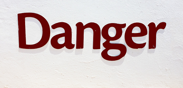 Danger, says embossed word on a wall.