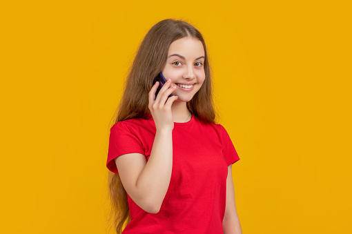 smiling girl with smartphone on yellow background.