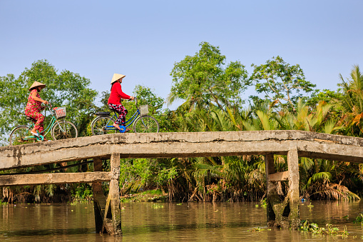 Vietnamese women riding a bicycle, Mekong River Delta, Vietnam