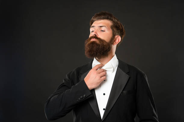 istock brutal gentleman in tuxedo on black background, suit 1458061119