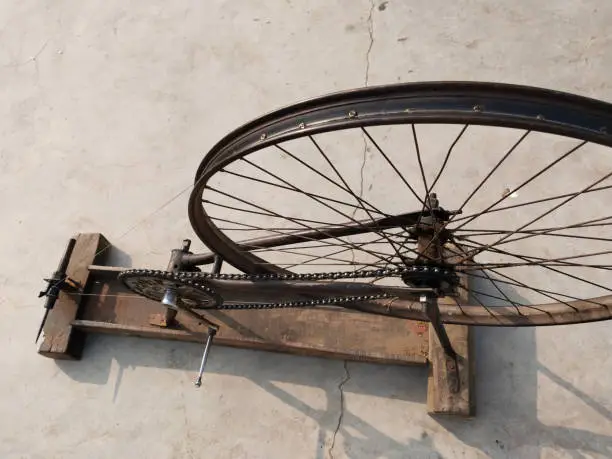 Photo of hand loom machine making thread on Charkha the spinning wheel in village at Varanasi, India. weaver prepares threads to make fabric with a handloom, spins yarn on an old fashioned spinning wheel.