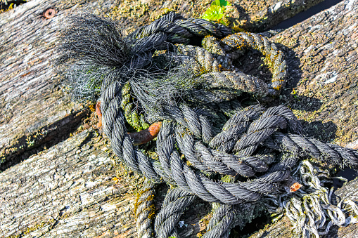 Boat ropes stretched on bollard in Germany.