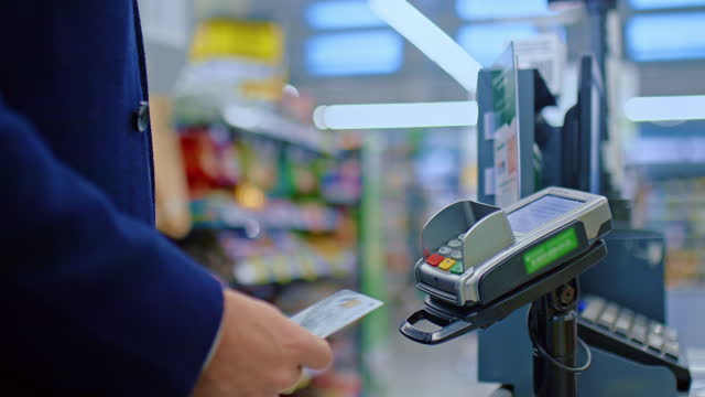 cashless payment in supermarket, man at check-desk , closeup view of hands with card, 4K, Prores