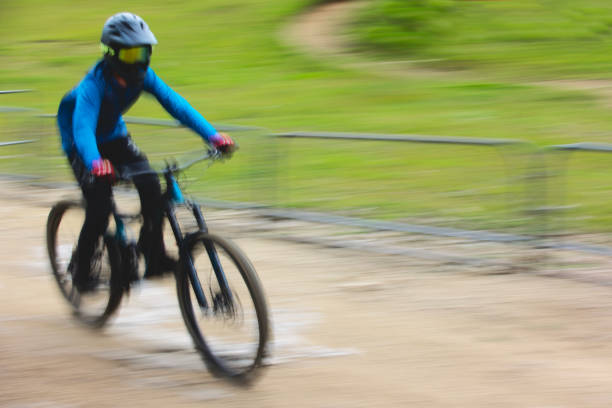 Man riding electric bike fast on mountain road, blurred motion back view