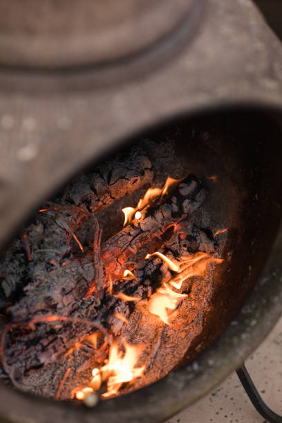 istock Rustic Chiminea Fire Pit Flaming with Cut Christmas Tree Pine Wood & Needles on a Cold Winter Day in South Florida 1458100492