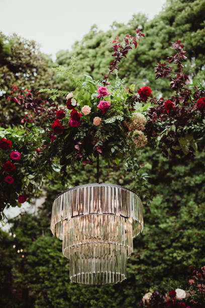 Crystal chandelier and floral arch outdoors for wedding