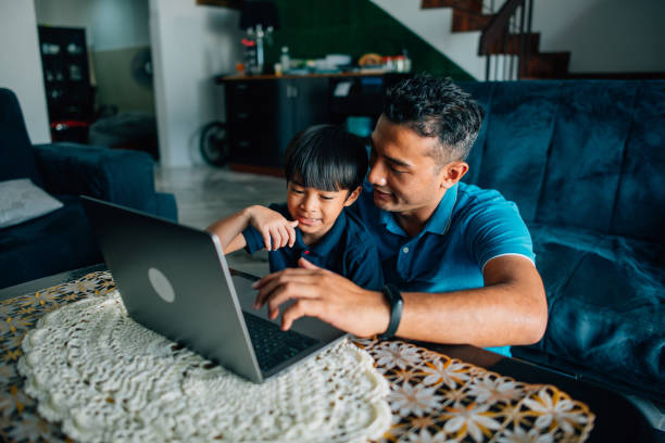 istock Father using the laptop with son at home 1458105168