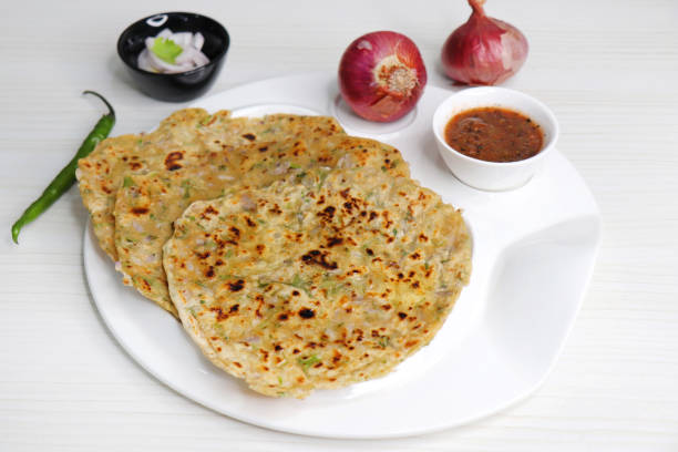 istock Indian traditional Hot Onion Paratha with tomato chutney. Indian onion stuffed Flatbread. also known as Pyaz ke parathe in Hindi. over a light background with copy space. 1458105532