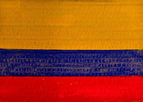 Flag of Colombia painted on cardboard with watercolors and a brush.