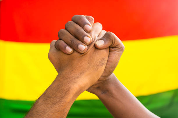 istock Two diverse hands joining hands against black history month flag to show unity - concept of support, activism and celebration 1458113029
