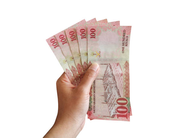 istock 100 Riyal Saudi money banknotes in hand. 1458118131
