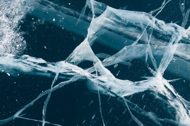 istock Transparent blue ice with cracks on Baikal lake in winter. 1458119361