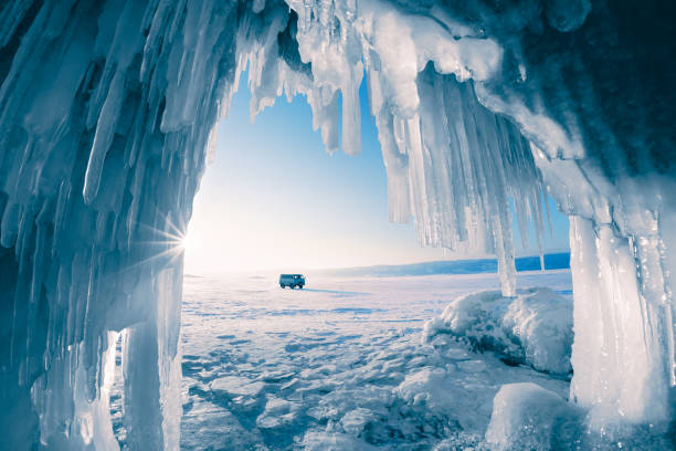 eishöhle mit eiszapfen am baikalsee bei sonnenuntergang. winter baikalsee, sibirien, russland - baikalsee stock-fotos und bilder