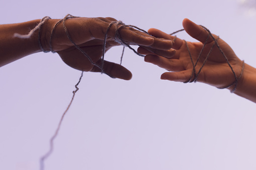 Hands connected with ribbon/string concept for Human Connection