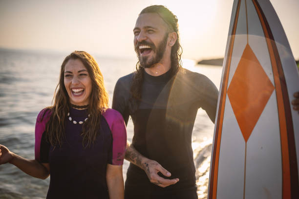 istock Surfer couple at the beach 1458126069